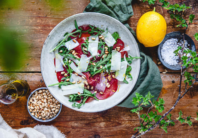 Sallad med bresaola, pinjenötter och citron på fat