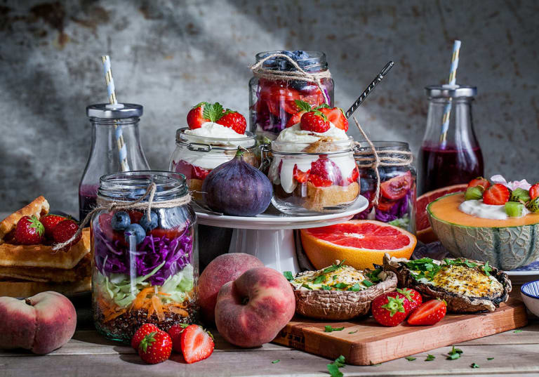 Brunch på ett bord med smoothie, grapefrukt, bär och jordgubbstrifle bland annat.