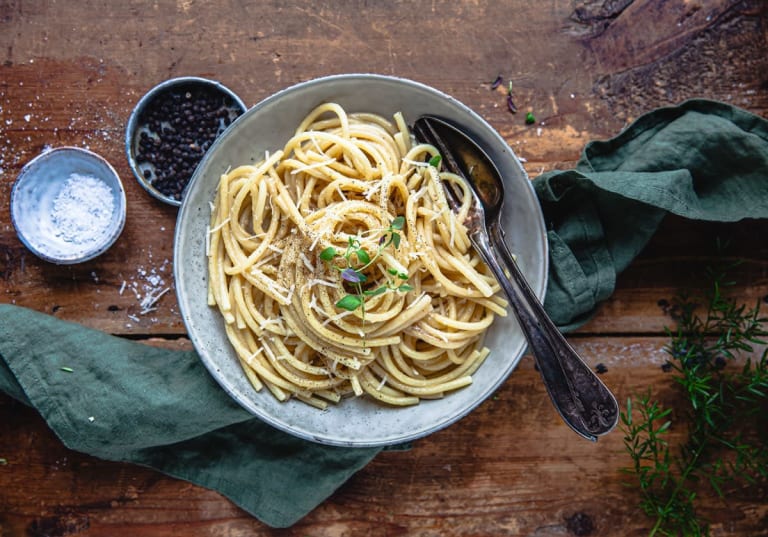 Cacio e pepe i en tallrik dukat på ett bord 