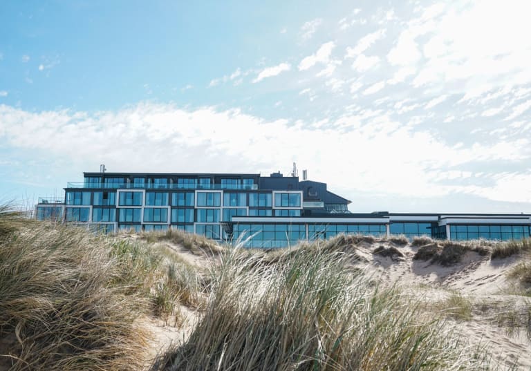 Sanddynor i förgrund och Hotel Tylösand i bakgrund