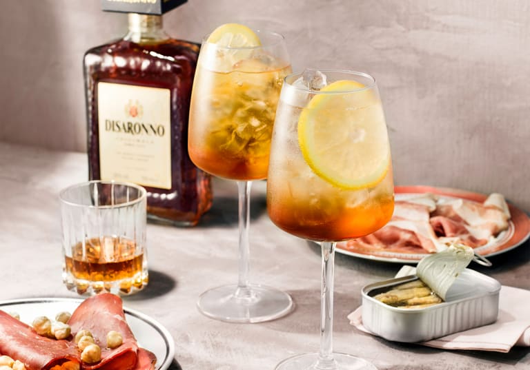 Disaronno Fizz med en flaska Disaronno i bakgrunden