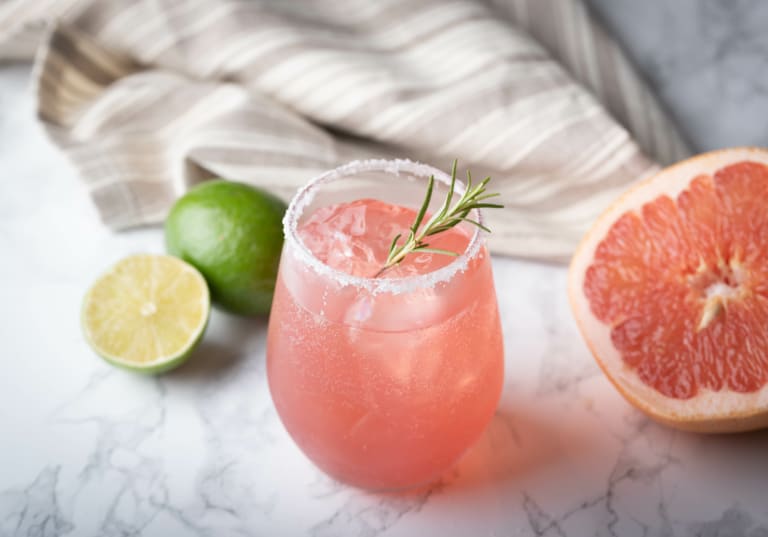 Paloma med en halv grapefrukt och lime på marmorbord