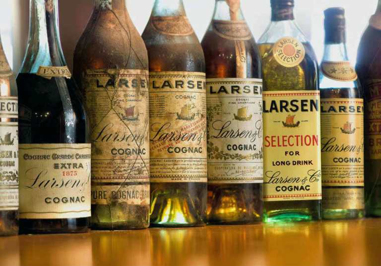 Samling av gamla flaskor Larsen Cognac