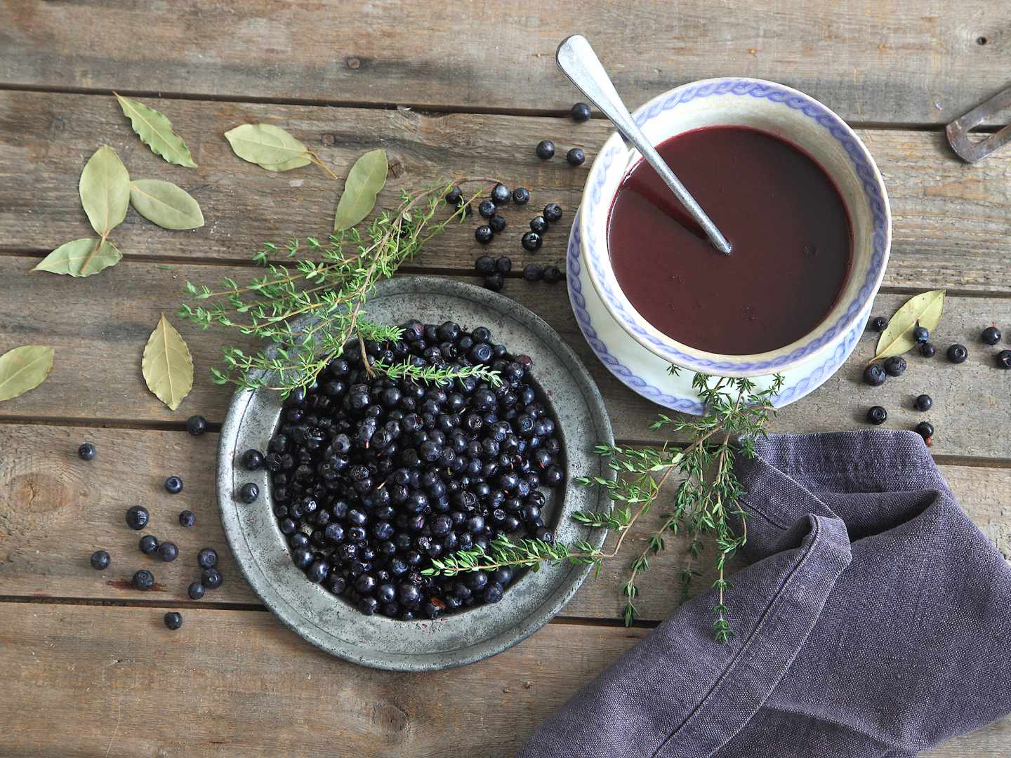 Blåbärssås på träbord bredvid en skål med blåbär.