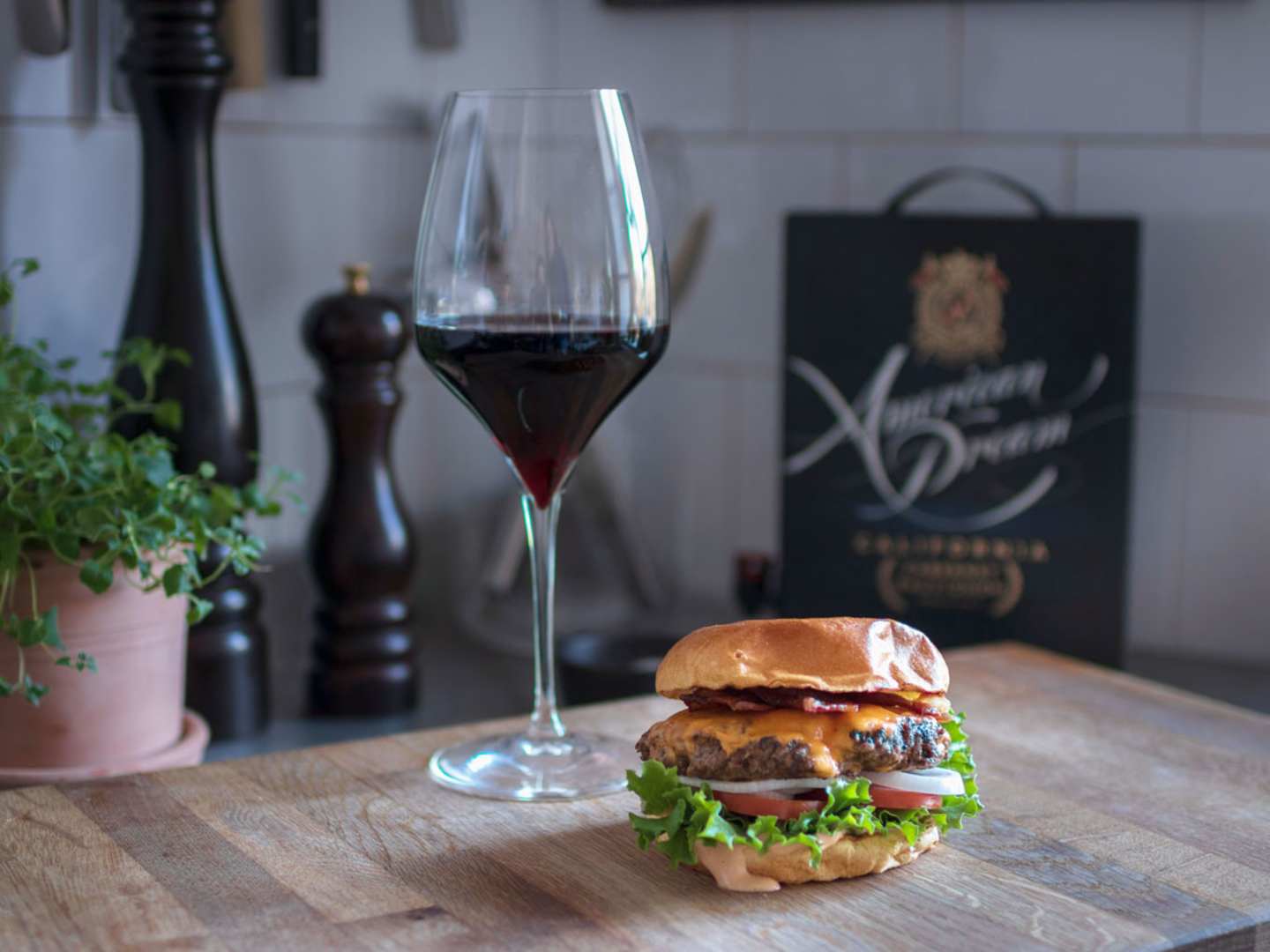 En hamburgare med bbq-sås och ett glas rött vin.