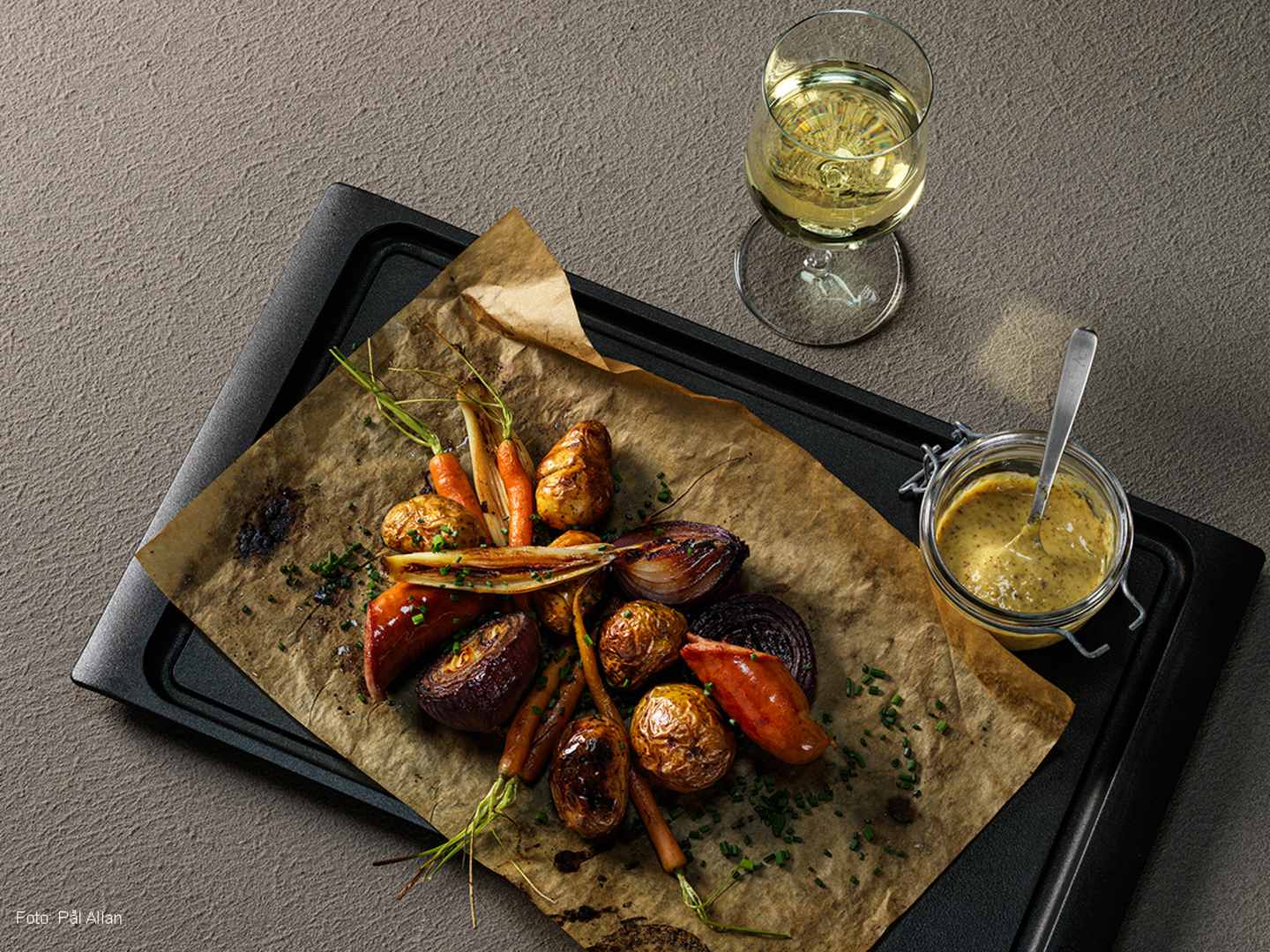 Bratwurstpanna med ett glas vitt vin