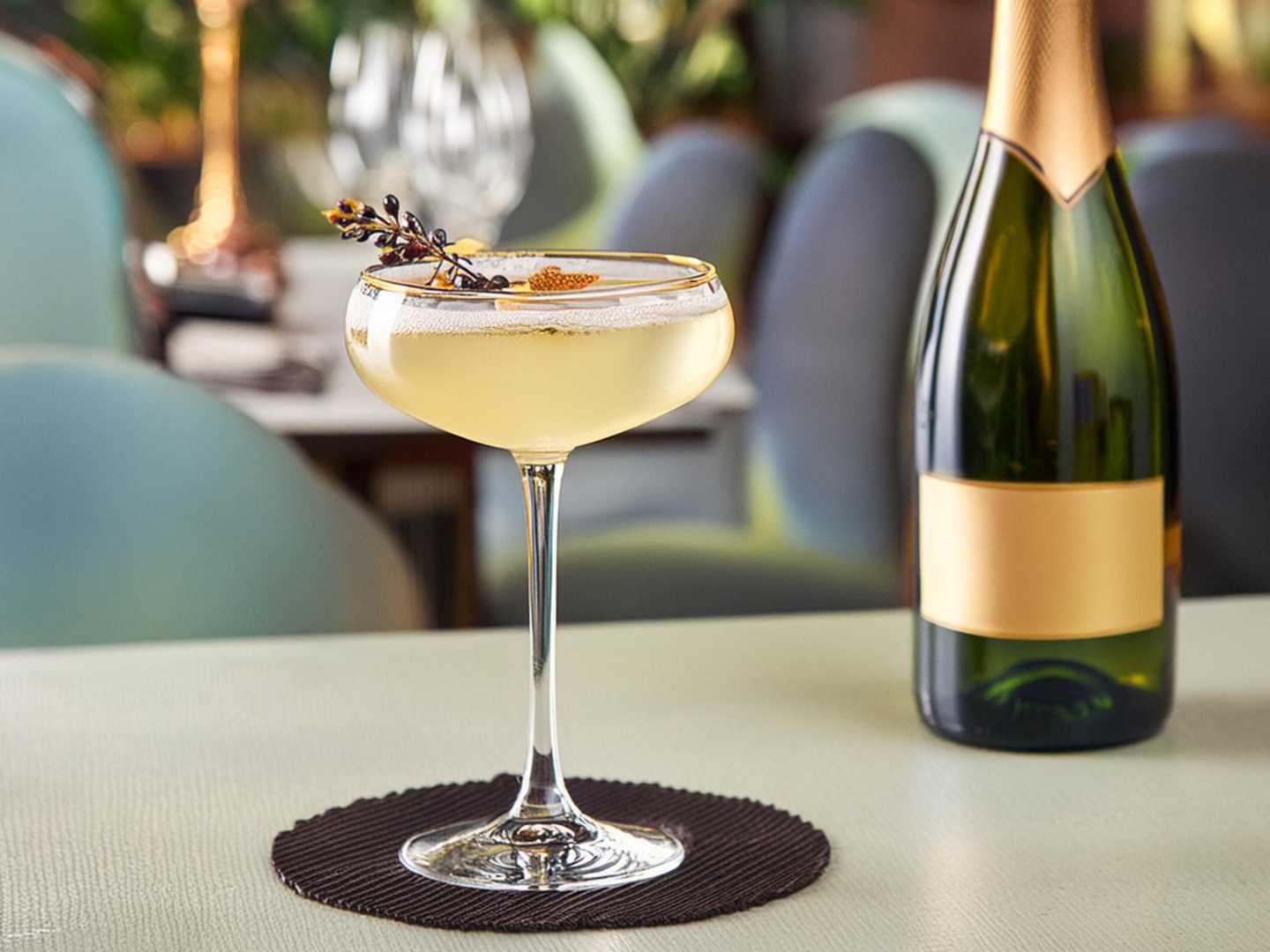 Champagnedrink på bord med champagneflaska.