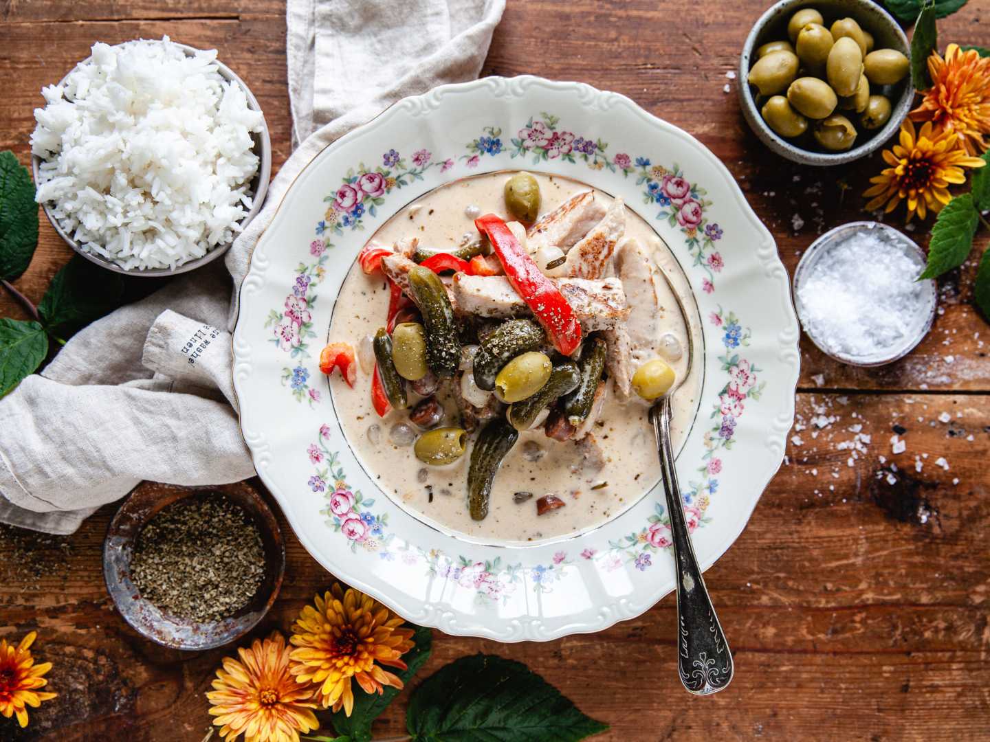 Kreolsk gryta på blommig tallrik på träbord.