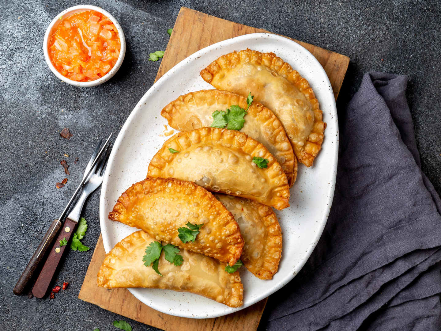 Empanadas med kyckling på vit tallrik.