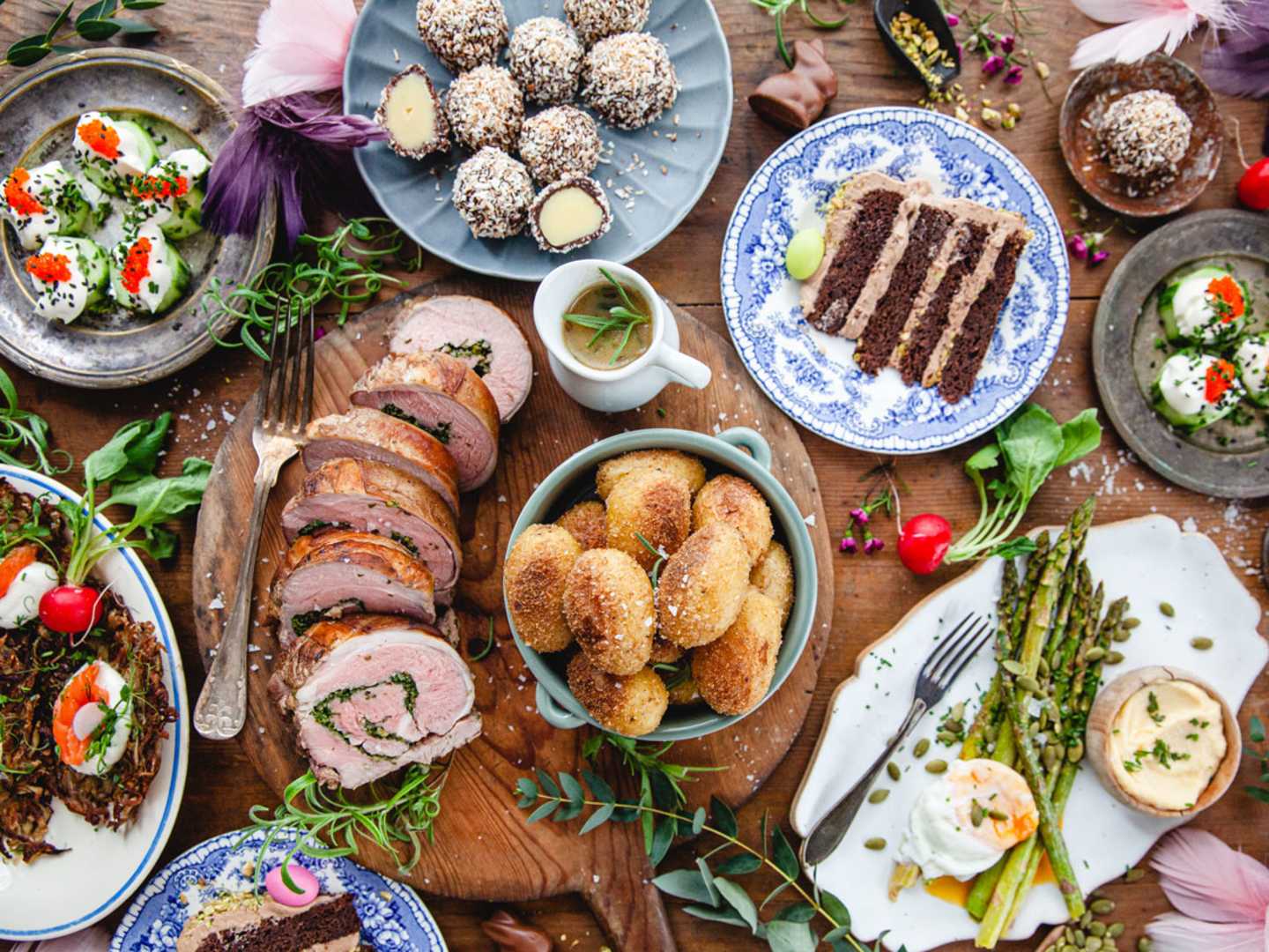 Påskmiddag uppdukat på ett träbord fotat uppifrån.