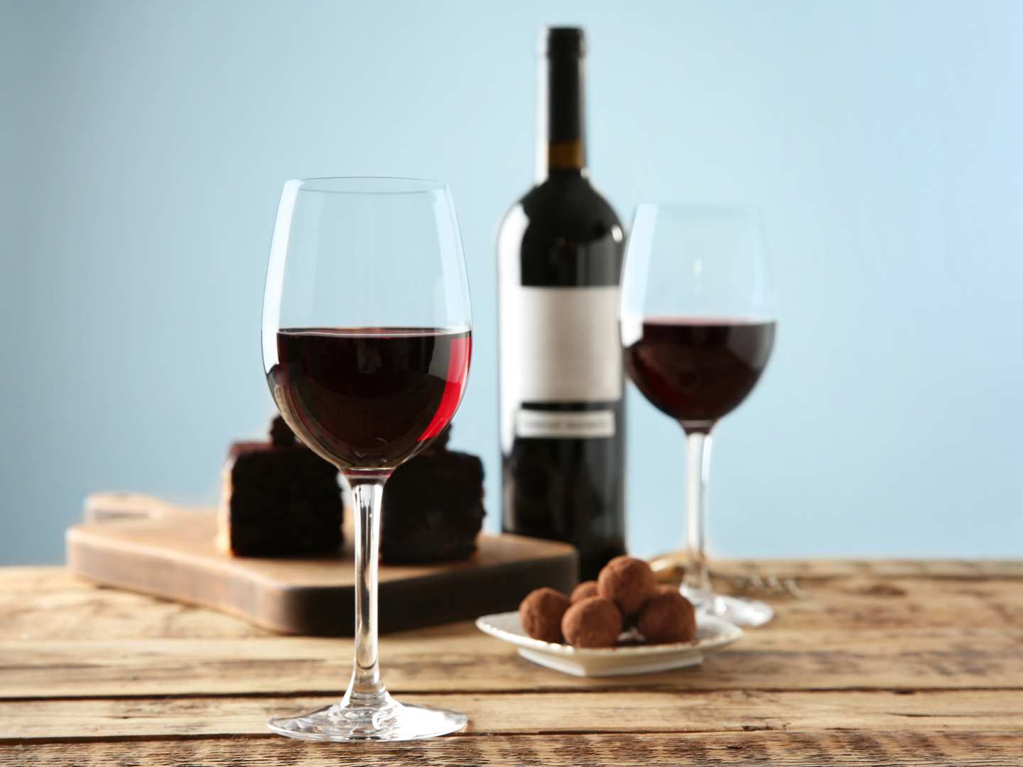 Vinglas med rödvin och fat med chokladtryfflar.