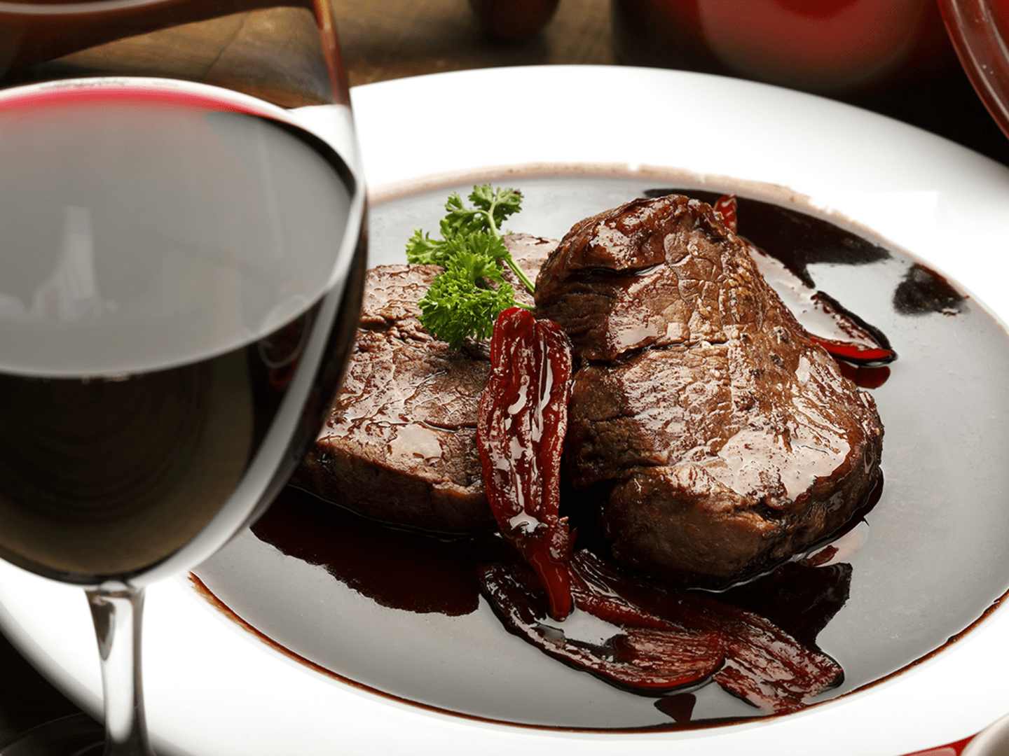 Vin i matlagning, här i rödvinssås och ett glas med rött vin.