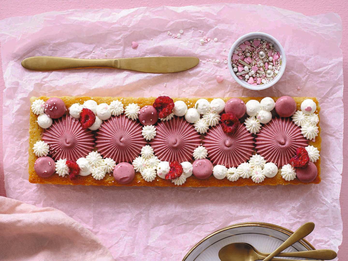 Vit kladdkaka dekorerad med hallon och pannacotta.
