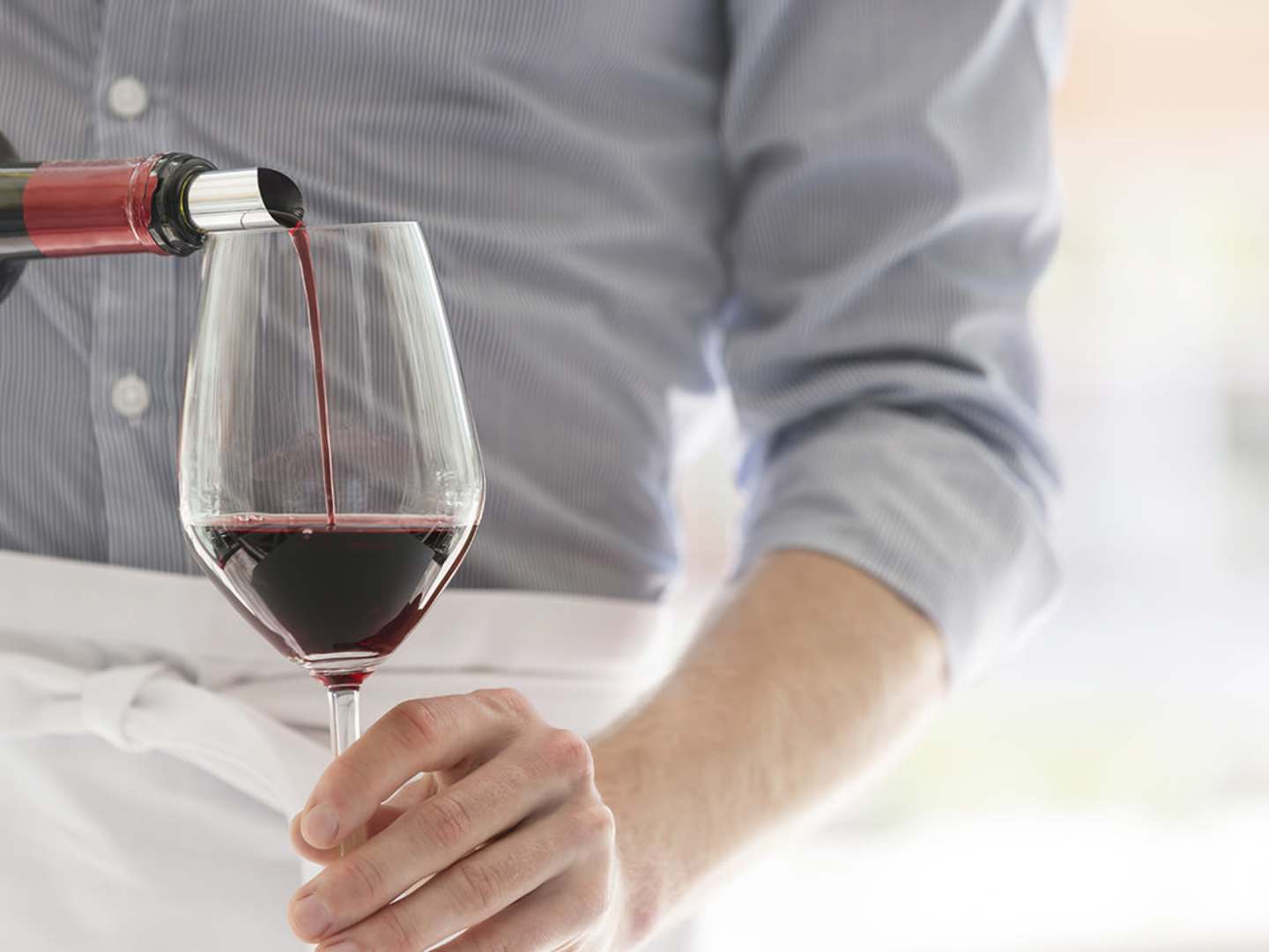 Rött vin av druvan grenache hälls upp i ett glas.