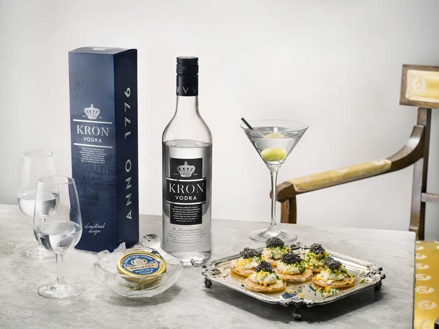Kronvodka förpackning och flaska med ett martiniglas och fat med tilltugg