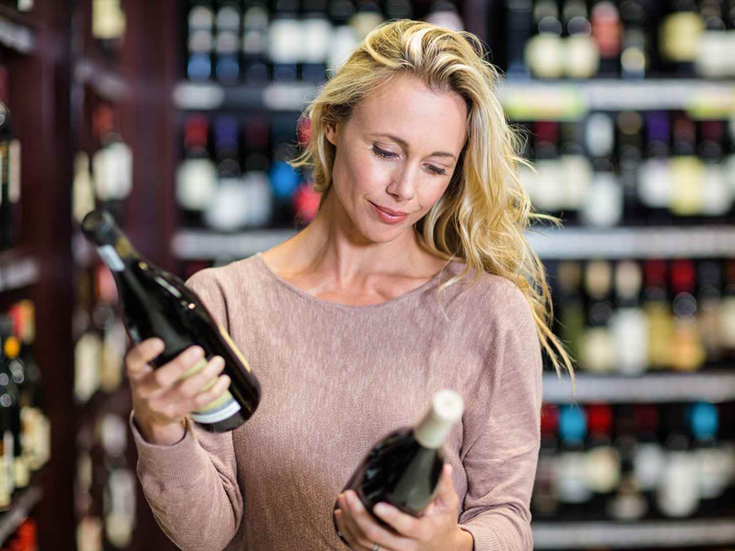 Kvinna väljer vin i butik