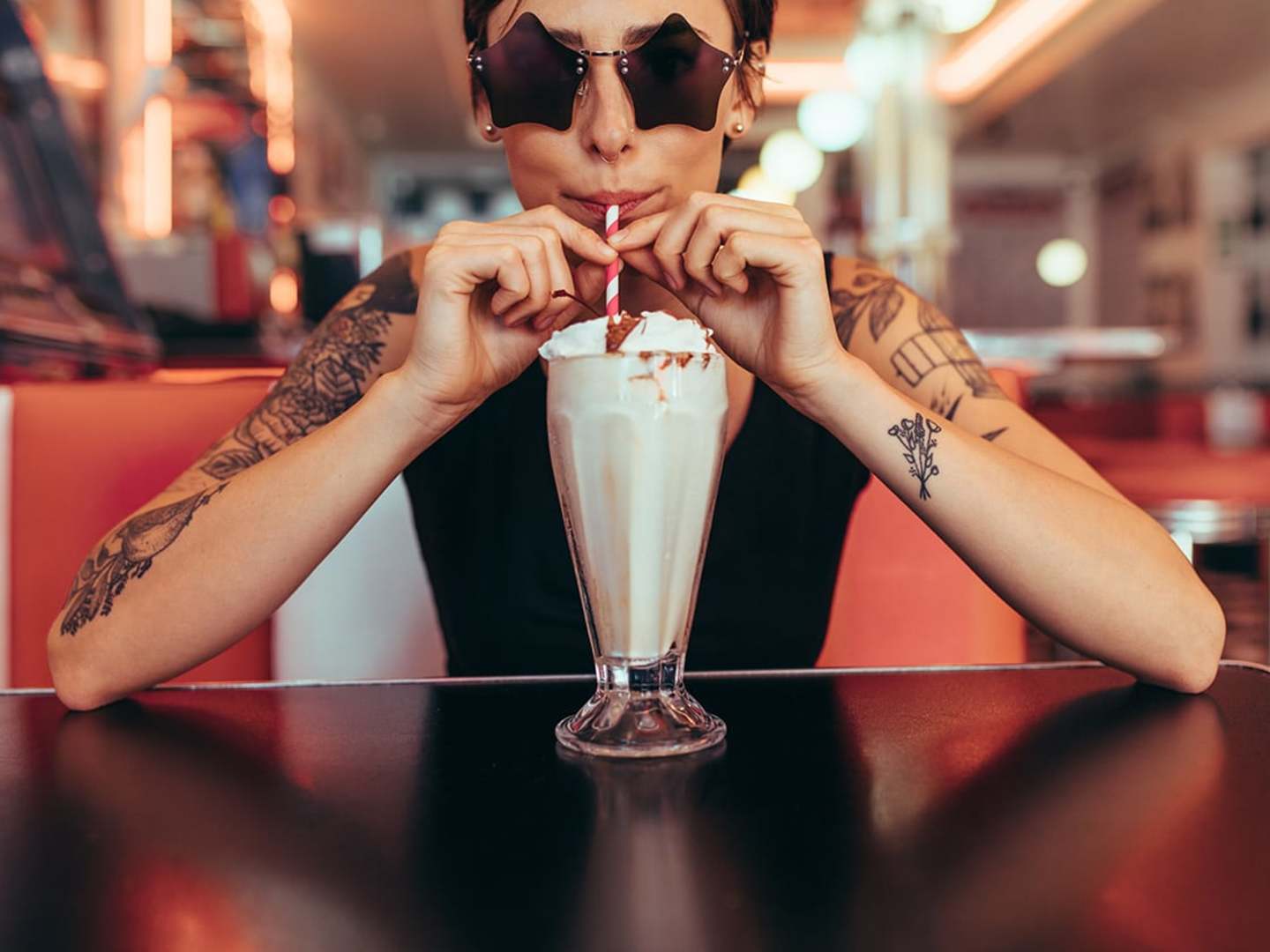 Tjej dricker milkshake på diner