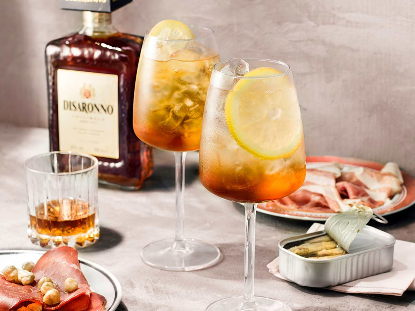 Disaronno Fizz med en flaska Disaronno i bakgrunden