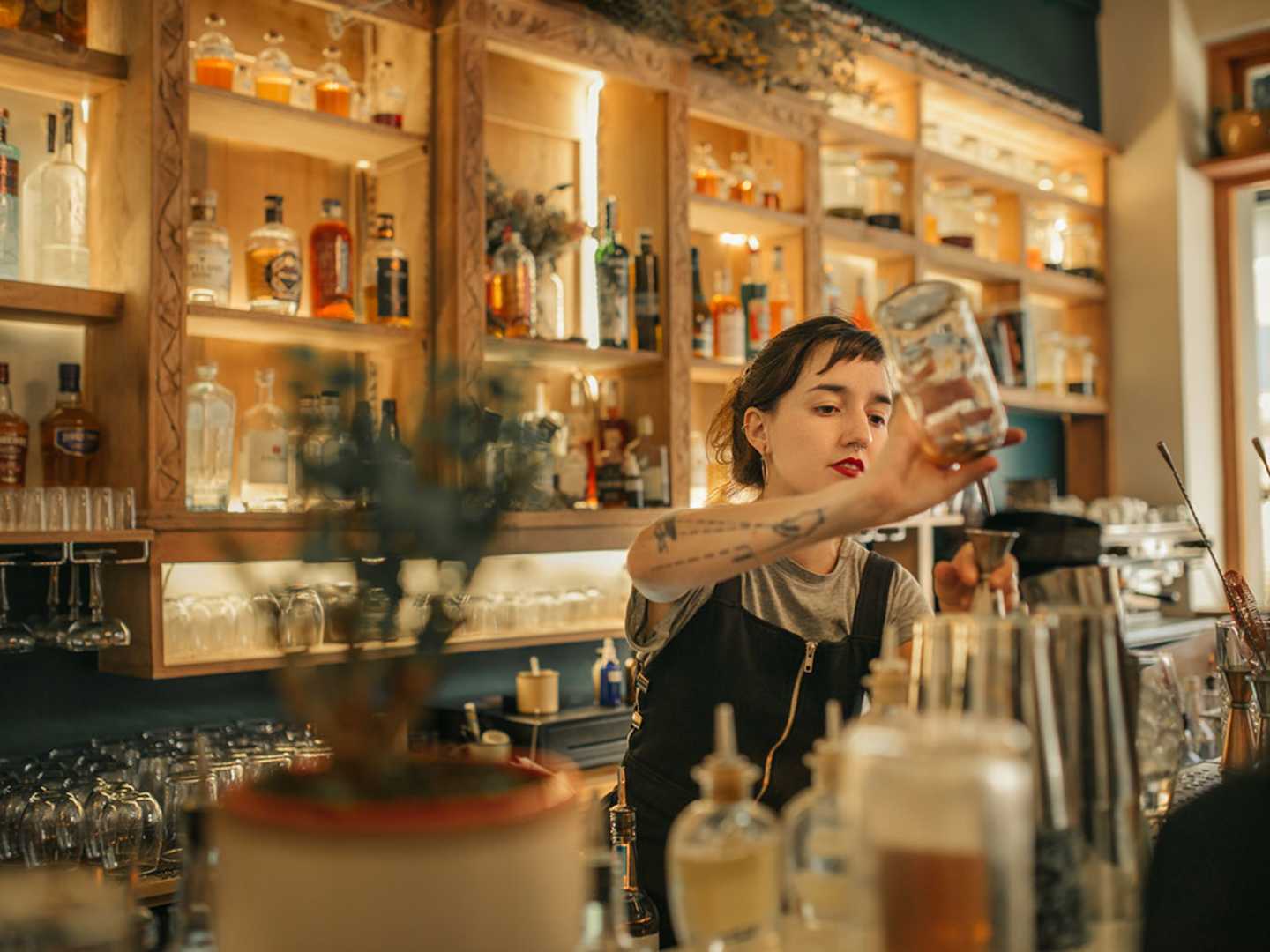 Kvinnlig bartender häller upp cocktail
