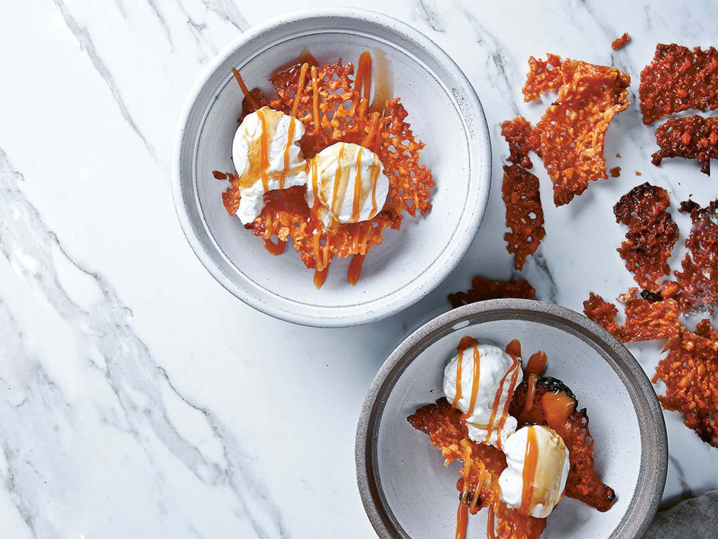 två skålar med yuzuglass med mandelflarn på marmorbord