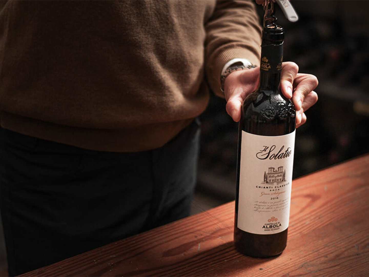 Castello di Albola vinflaska med hand på