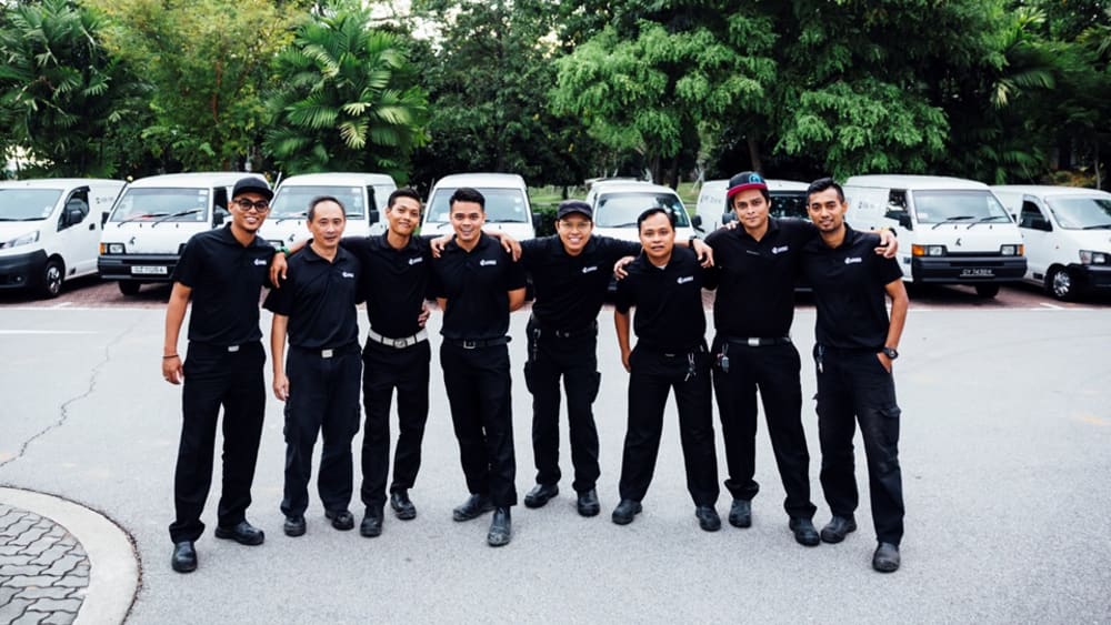 Singapore team standing on a parking lot and smiling