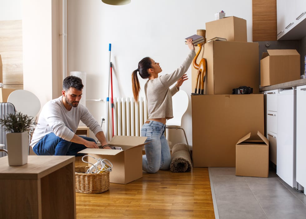 Young couple unpacking cardboard boxes at new home.Moving house.Real estate. - rent reduction letter