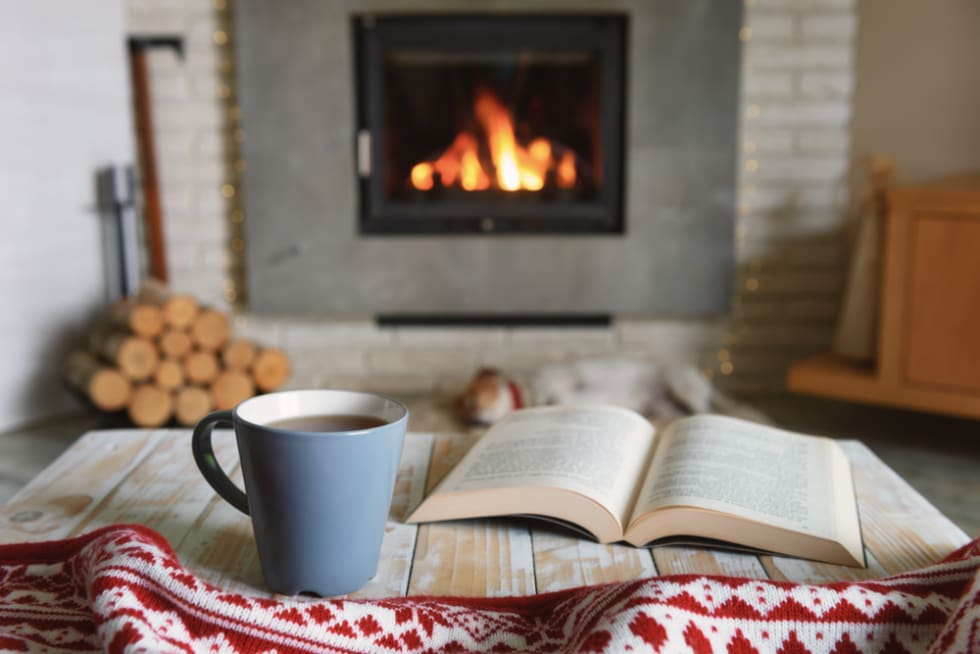 Book and tea near fireplace