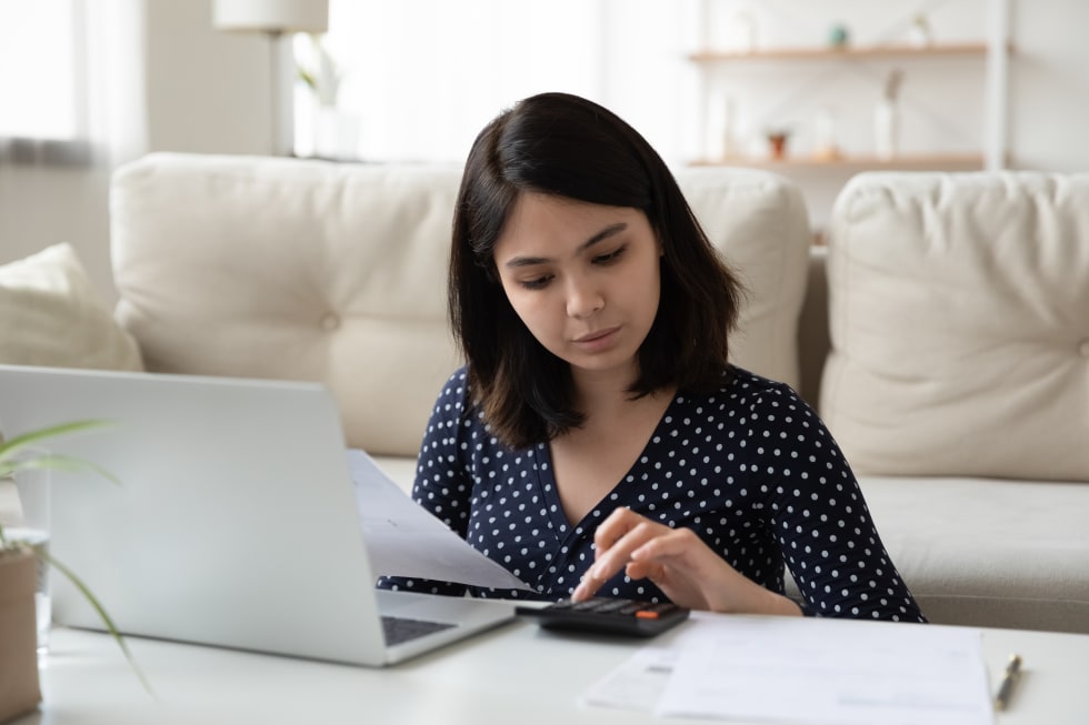 young woman work on laptop mange household finances expenditures - apartment budget