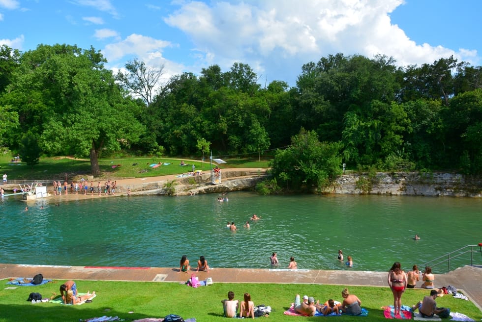 Barton Springs Pool in Austin, TX, with people.