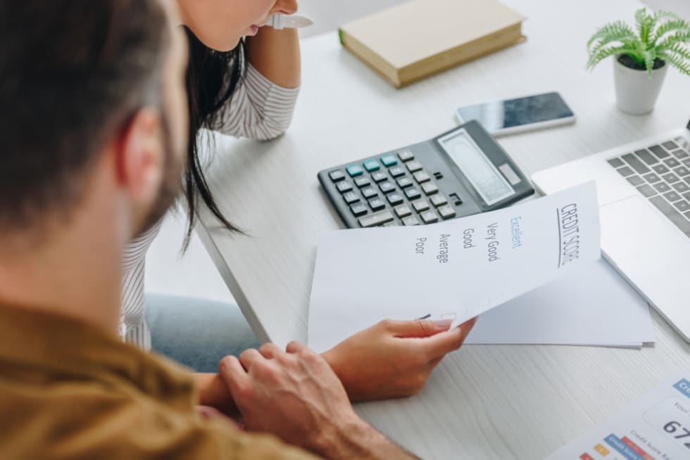 cropped view of man holding hand of woman with credit score