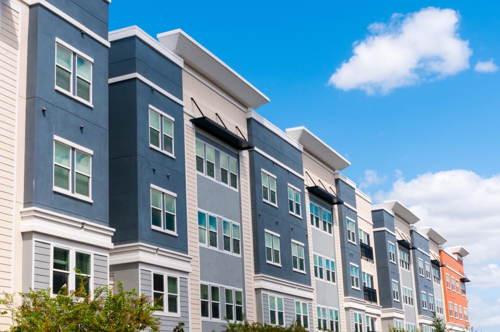 Modern luxury urban apartment building exterior with blue sky.