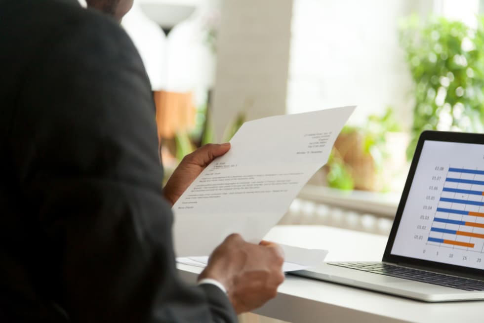 holding business mail checking paper correspondence at workplace, over the shoulder view