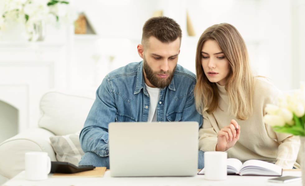 couple managing expenses with laptop and checking accountancy and bills, panorama