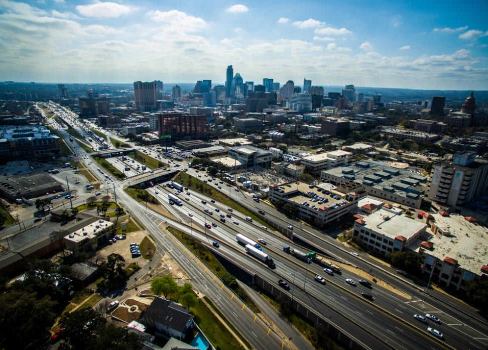 Aerial View over Austin Texas Interstate 35 busy traffic sunny day Capital City Cityscape Urban Skyline