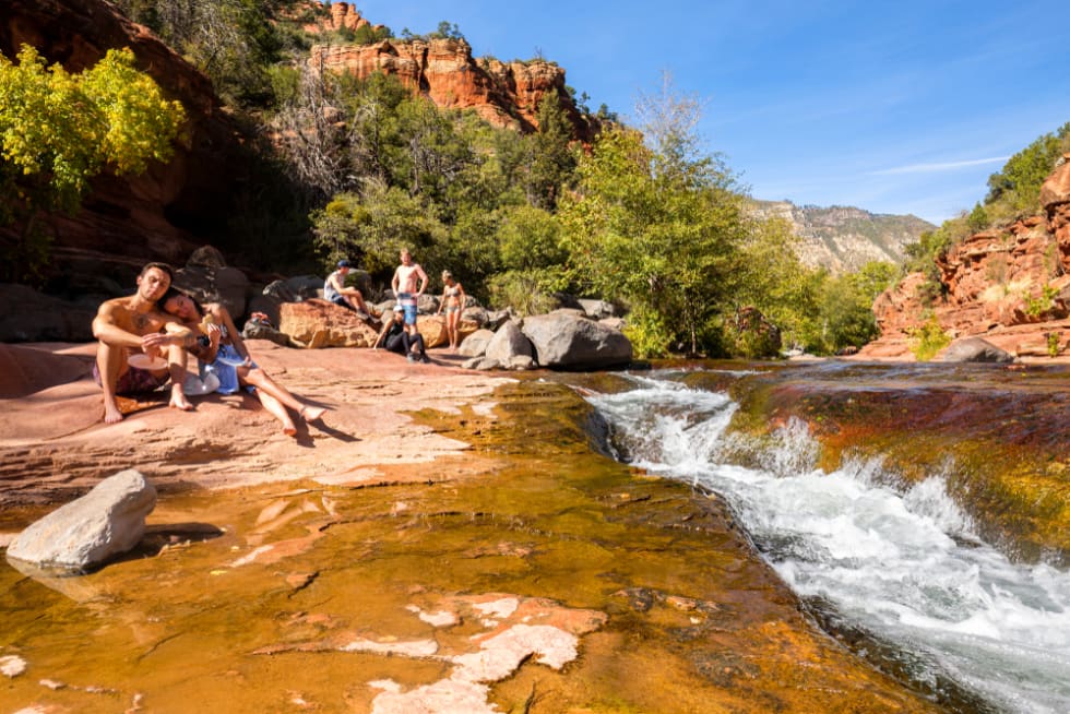 Visitors enjoying the natural beauty of Slide Rock State Park with its rock water slides in Oak Creek Canyon.