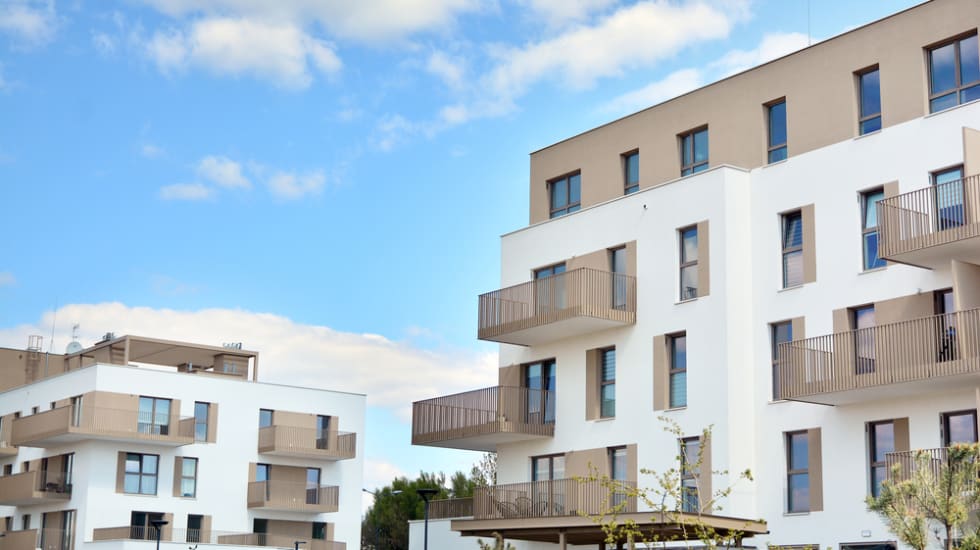  Contemporary residential building exterior in the daylight. Modern apartment buildings on a sunny day with a blue sky. Facade of a modern apartment building