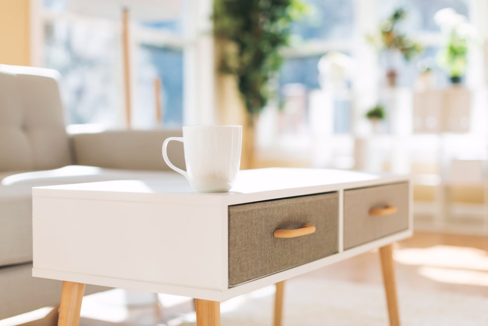 Luxury interior home with coffee cup and gray midcentury loveseat