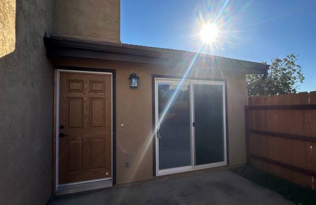 2BR/1.5BA 2-story condo in El Cajon, gated community with sparkling pool, 2 car attached garage, private backyard, balcony with a view, and more.