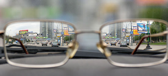 A pair of glasses showing a street in clear view with a blurry background.