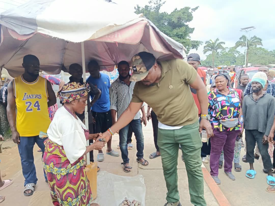 An official greets a market woman during the outreach