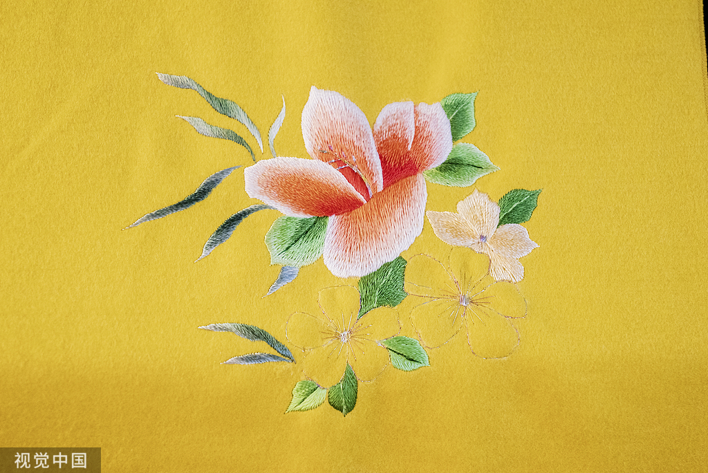 Orange flowers embroidered on yellow fabric