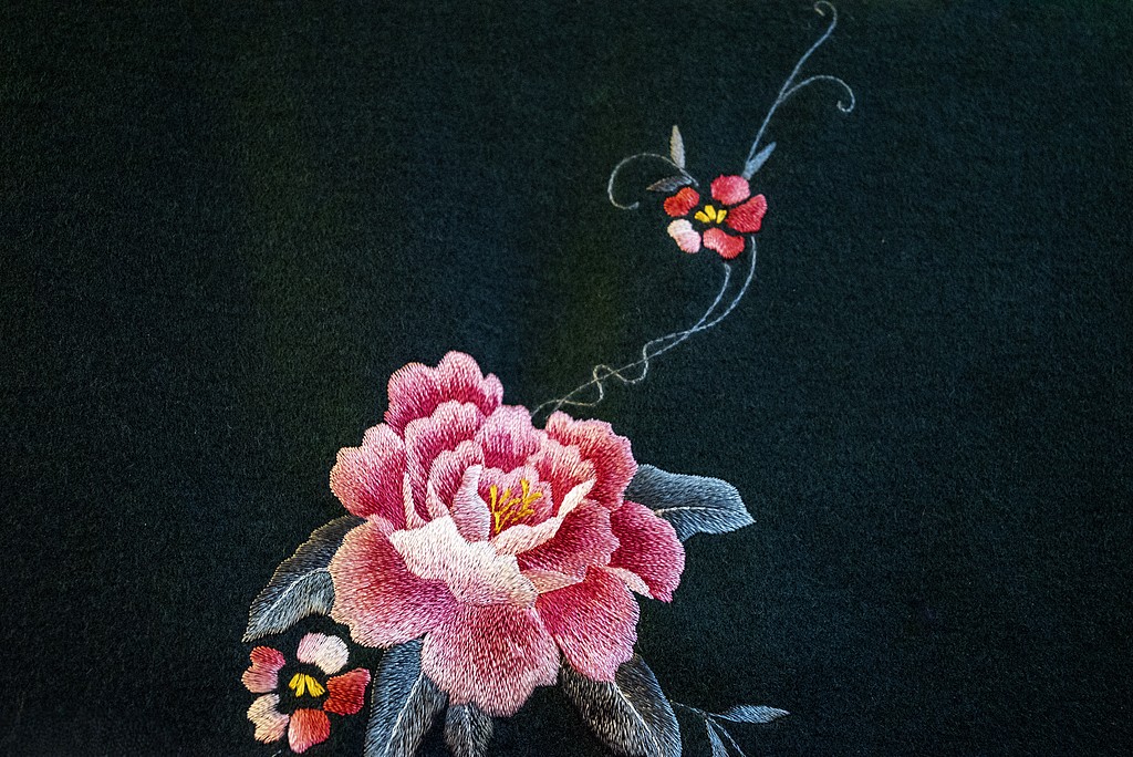 Pink peony embroidered on black fabric