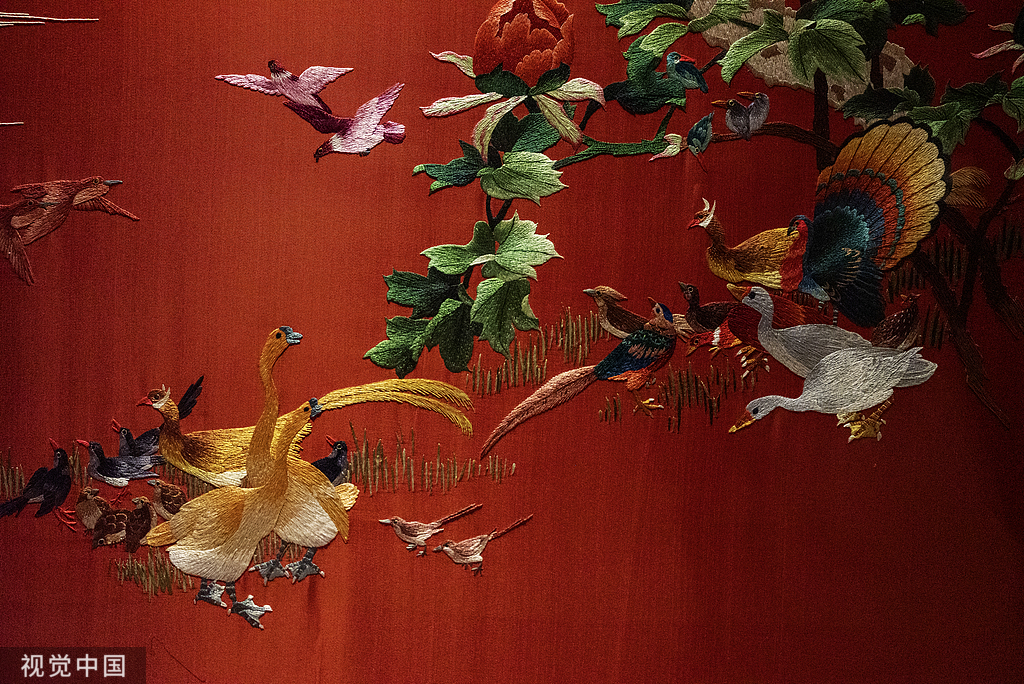 Birds and flowers embroidered on red fabric