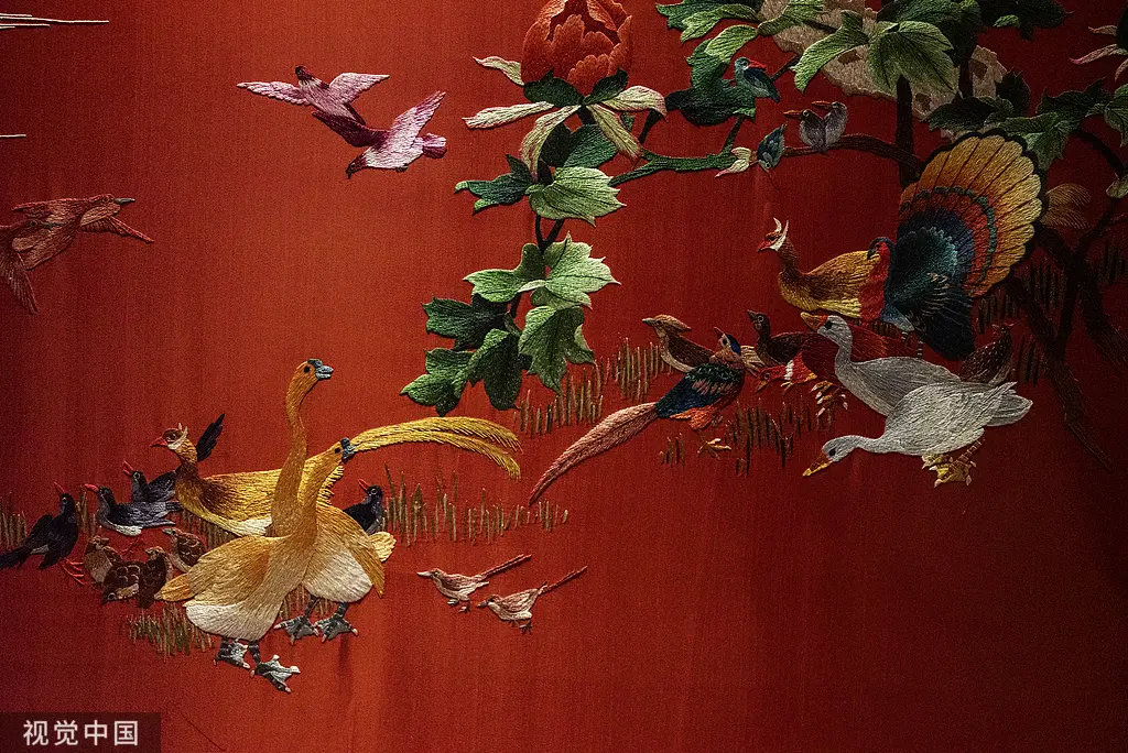 Birds and flowers embroidered on red fabric