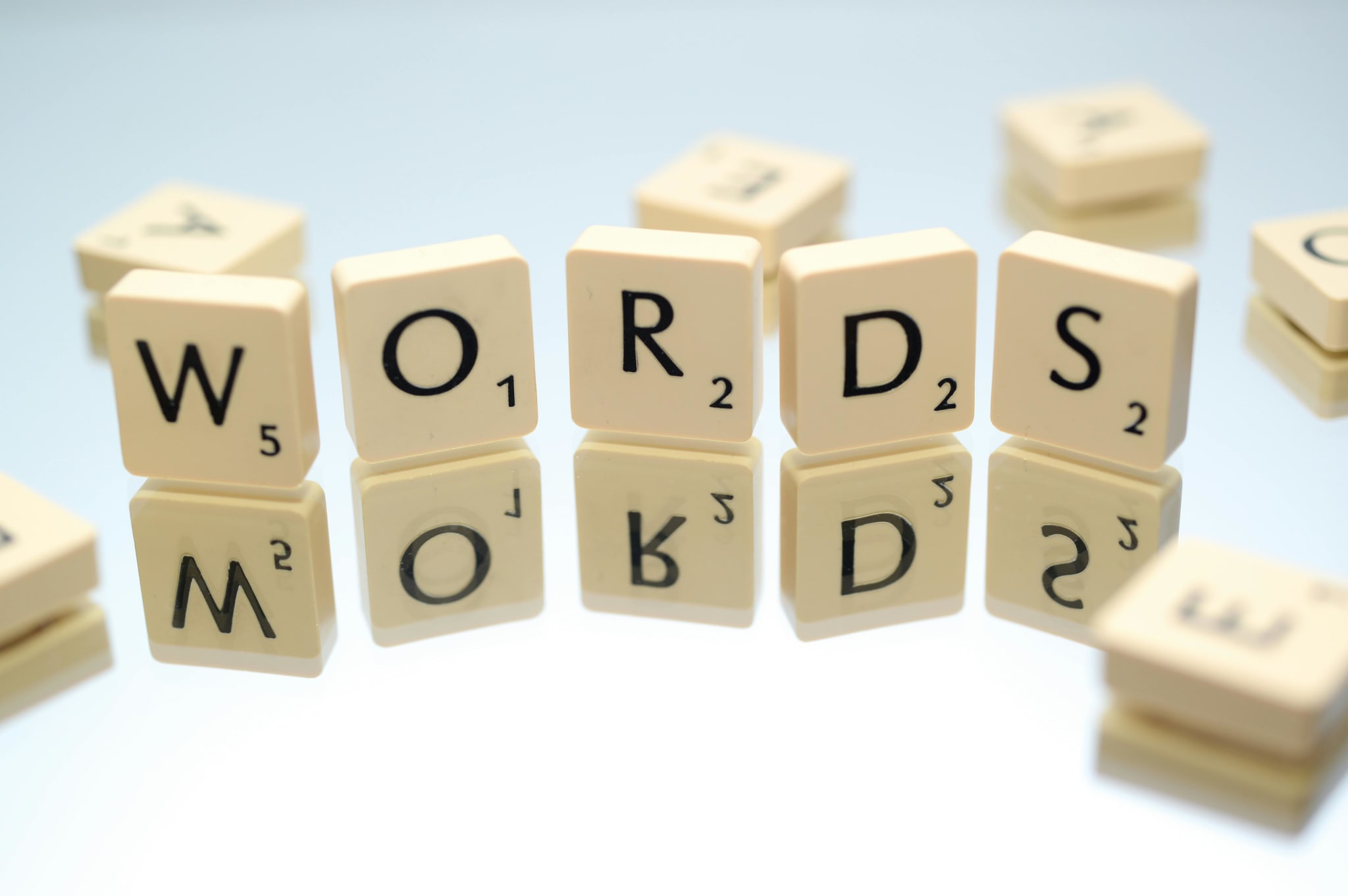 Scrabble tiles arranged on a reflective surface