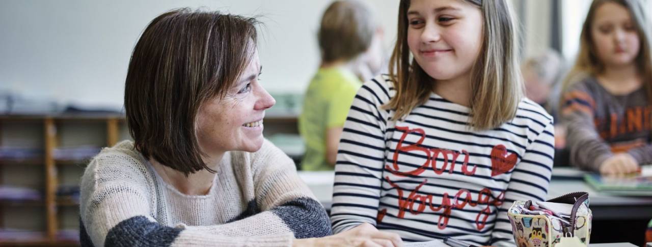 En lærer hjelper en av elevene sine med skoleoppgaver. Foto: Øivind Haug