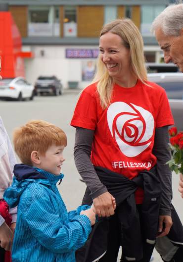 Jonas Gahr Støre og to barn snakker sammen