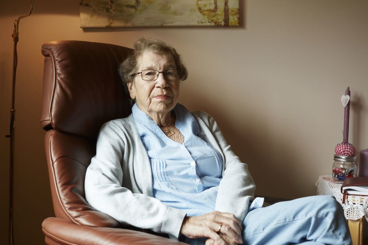 Portrett av en eldre kvinne som sitter i godstolen sin. Foto: Øivind Haug