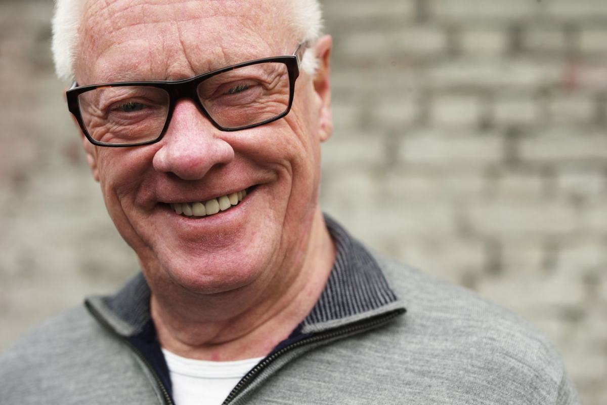 Portrettbilde av en smilende eldre mann med briller. Foto: Øivind Haug